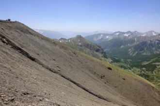 View of slope in high Alps with gravel scree on ring road Road loop around mountain peak Cime de la
