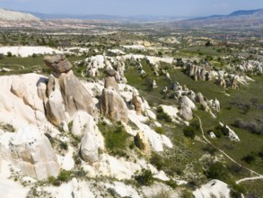 Rock formations and green areas in a hilly landscape with a wide view, aerial view, fairy chimneys