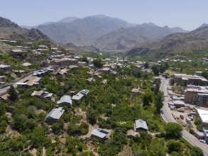 Panoramic view of a village along a road amidst green hills and mountains, aerial view, Meghri,