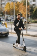 Ein junger Mann nimmt mit einem E-Scooter am öffentlichen Straßenverkehr in einer Stadt teil,