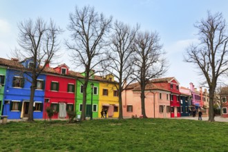 Strollers, typical street scene in winter, colourful facades of fishermen's houses in Burano,