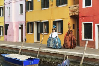 Two dressed up woman, Venetian costumes with masks, colourful facades, Burano, Venice, Veneto,