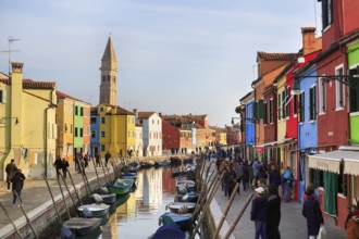 Strollers along the canal, typical street scene in winter, campanile of the church of San Martino,