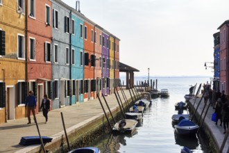 Strollers along the canal, typical street scene in winter, colourful facades of fishermen's houses
