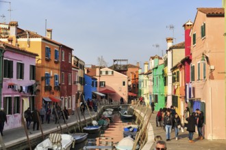Strollers along the canal, typical street scene in winter, fishermen's houses in different colours,