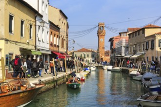 Strollers along the canal, typical street scene in winter, campanile of the church of San Giacomo,