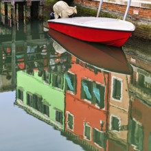 Colourful façade details reflected in the water of a canal, motorboat, Burano, Venice, Veneto,