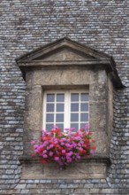 Dormer window with glazing bars in a historic house, floral decoration, old town of Guingamp,