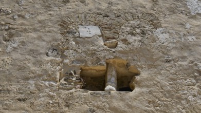 Close-up of a historic stone wall with rustic details, built-in antique column, basilica, church,