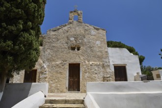 Stone church façade with steeple, rustic entrance, clear sky, basilica, church, Agios Theologos,