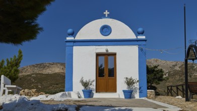 White chapel with blue façade and cross in a peaceful, mountainous landscape, Panagia tou