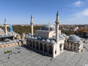 Spacious mosque complex with wide squares and several minarets under a clear sky, aerial view,