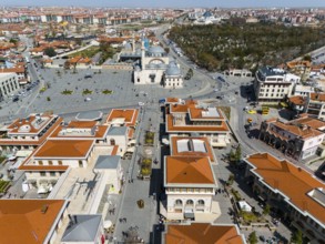 Bird's eye view of town square and surrounding buildings with characteristic red roofs, aerial