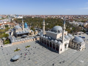 Large mosque with spacious square and numerous visitors on a sunny day, aerial view, Mevlânâ