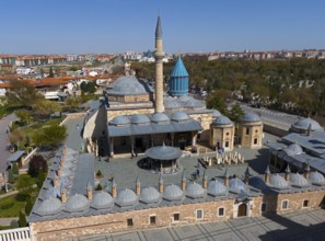 The Mevlana Museum in Konya with its characteristic blue domes and minaret on a sunny day, aerial