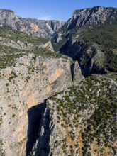 Majestic rock formations surrounded by green terrain and clear skies, aerial view, Saklikent Gorge,