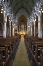 Neo-Gothic church interior with high arches and wooden benches, St Mary Abbot Church, Kensington,