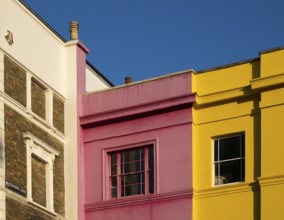 Colourful building facades in pink, yellow and white, blue sky, Portobello Road, Notting Hill,