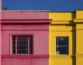 Colourful building facades in pink and yellow, blue sky, Portobello Road, Notting Hill, London,