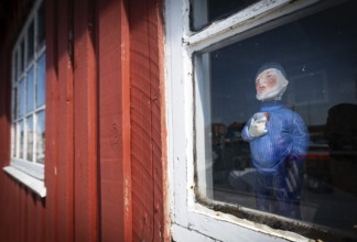 Sailor doll standing behind the window of a red wooden house, harbour, Ringkøbing, Ringkøbing