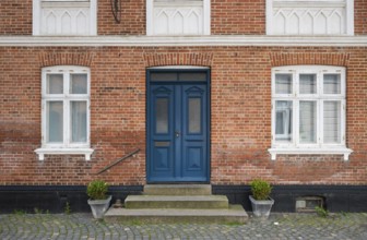 Brick façade with a striking blue door and potted plants, Old Town, Ringkøbing, Ringkøbing Fjord,