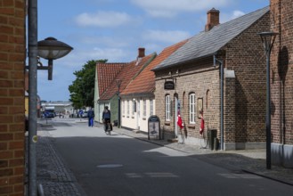 Street with historic brick houses and cyclists, Old Town, Ringkøbing, Ringkøbing Fjord, Denmark