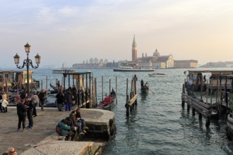 Boat dock at St Mark's Square, San Giorgio Maggiore church in the background, evening sky, Venice,