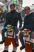 Funny costumes, two men with sunglasses, riding piggyback, illusion, equestrian costume, carnival