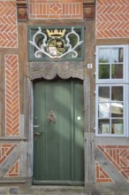 Door with coat of arms and golden crown at the entrance to the Eulenspiegel Museum, half-timbered