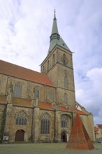 Romanesque St Andrew's Church and Sculpture of the Word, rusty steel sculpture with words, pyramid,
