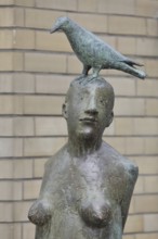 Sculpture Standing with bird by Karl Ulrich Nuss 1997, nude female figure with dove on her head,