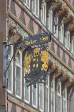 Nose plate with golden year 1989 on the brick house, half-timbered house, window, wrought ironwork,