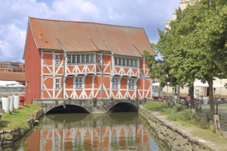 Red historic half-timbered house vault on the canal Grube, idyll, shore, Wismar,