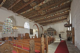 Interior view of the Church of the Holy Spirit with painted wooden ceiling, pulpit, winged altar