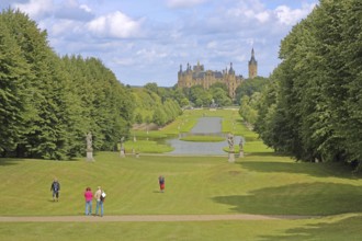 Castle garden with pedestrians and castle, Schwerin, Mecklenburg-Vorpommern, Germany