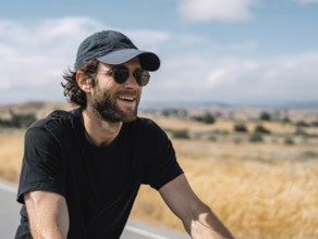 A man rides a bicycle and smiles in a friendly manner, AI generated, AI generated