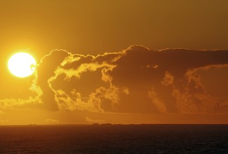 Intense sunset over the sea with dramatic clouds and colours, crossing between Orkney and Shetland
