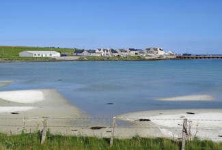 Coastline with sand and village by the shimmering blue sea, Pierowal, Westray, Orkney Islands,