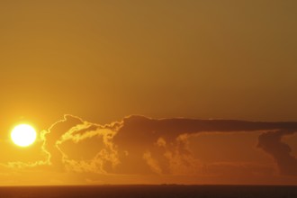 Sunset over the sea with intense orange clouds, crossing between Orkney and Shetland Islands,