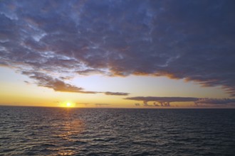 View of the sea at sunset with clouds and colourful sky, crossing between Orkney and Shetland