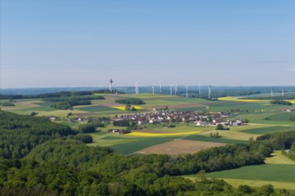 Village with fields and wind turbines in a hilly, green landscape, near Böhmenkirch, Swabian Alb,