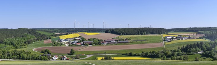 Panorama of a rural landscape with fields and wind turbines under a blue sky, near Böhmenkirch,