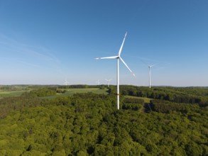 Wind turbine landscape in the middle of a forest under a blue sky, near Westerheim, Swabian Alb,