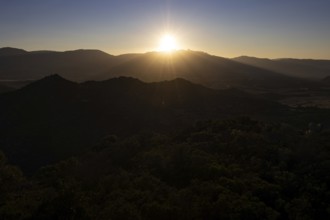 The sun sets behind the mountains on the Mediterranean island of Sardinia, Monte Nai, Costa Rei,