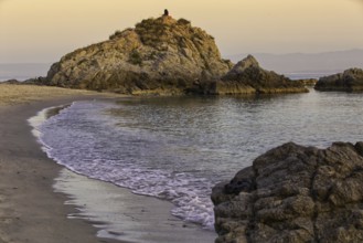 Rocky beach at sunset with gentle waves and a calm atmosphere, Ricadi, Capo Vaticano