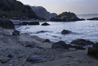 Coastline at dawn with dark rocks and calm sea, Ricadi, Capo Vaticano