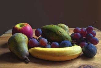 Fresh fruit arrangement of pears, grapes and bananas on a wooden table, Willich, North