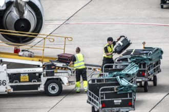 Aircraft being unloaded after landing, luggage being loaded, Düsseldorf International Airport.