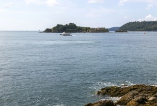 Ferry boat passing Drake's Island viewed from West Hoe, city of Plymouth, Devon, England, UK