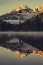 Lake Staz near Sankt Moritz in the Engadin in Switzerland. Morning atmosphere with fog in autumn.